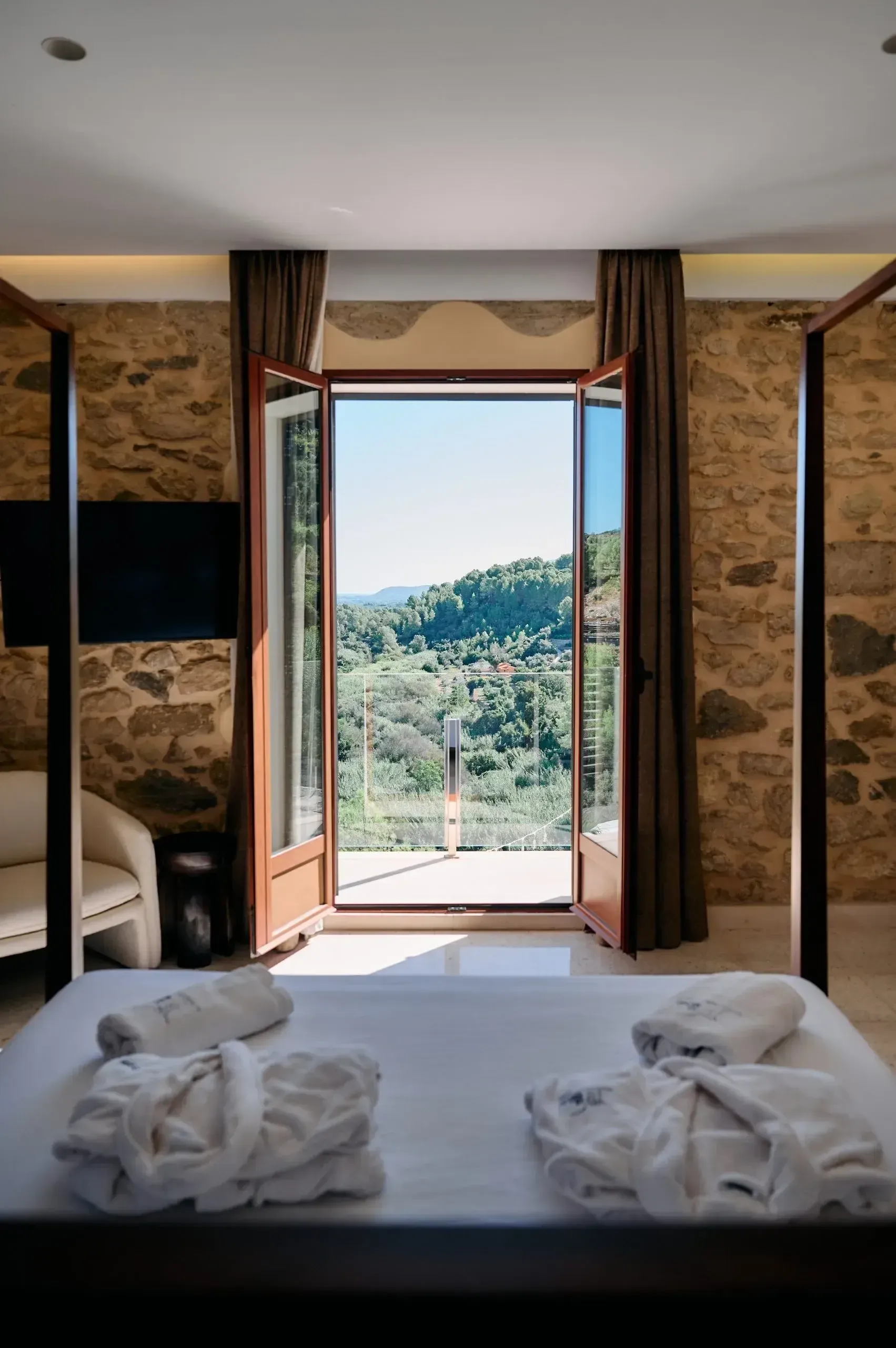 A bed facing an open window over the Denia valley