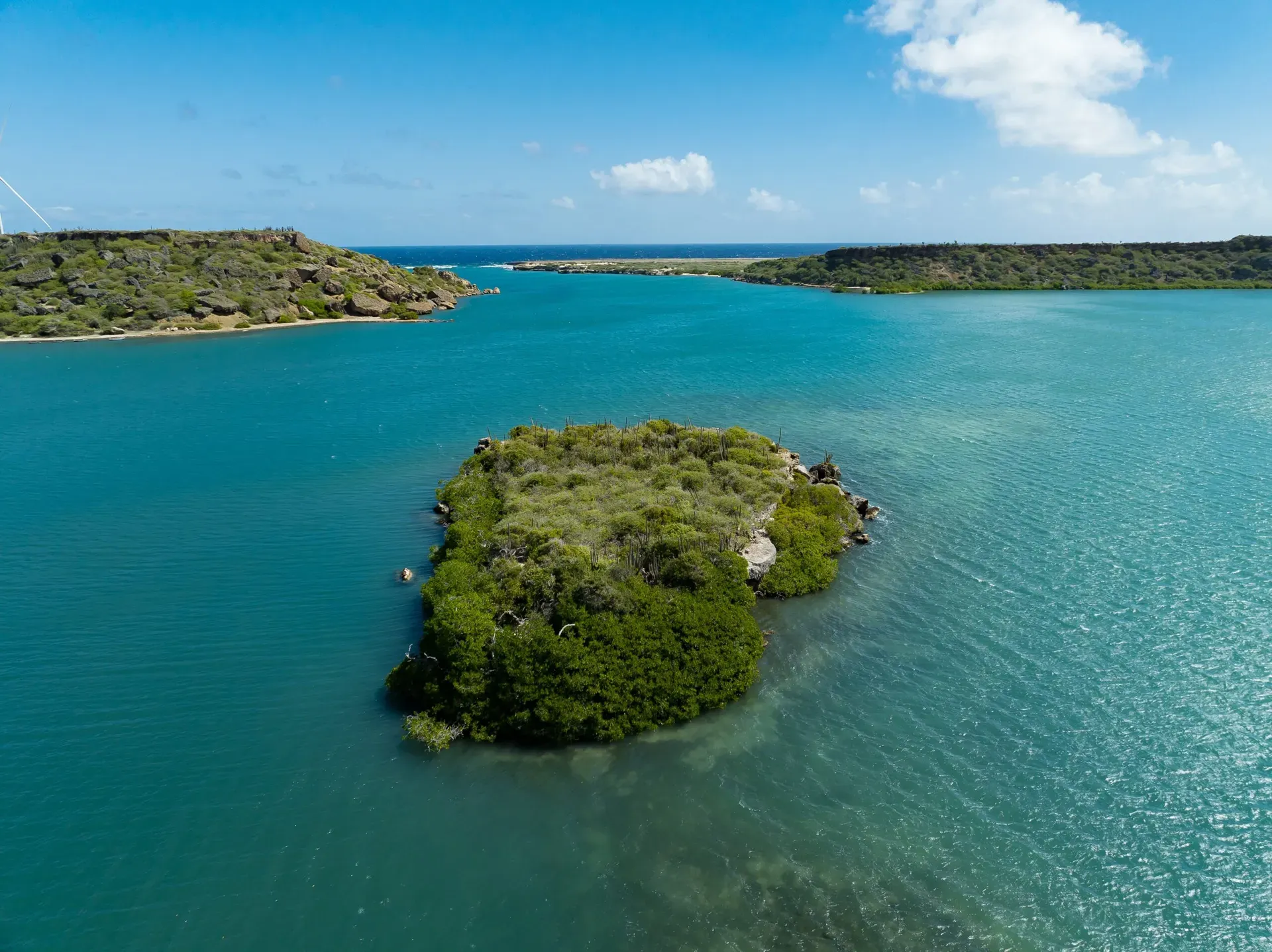Sint Joris Bay from above, with a small green island in turquoise water