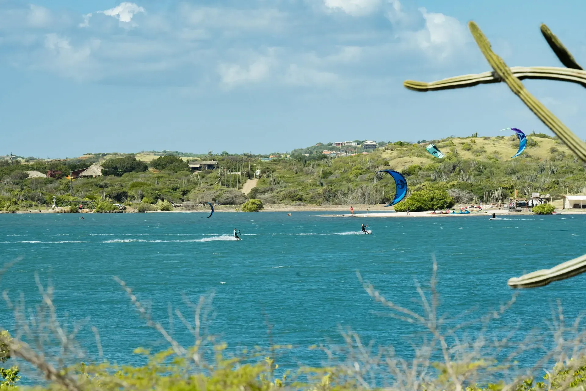 Kitesurfers on Sint Joris Bay below green hills