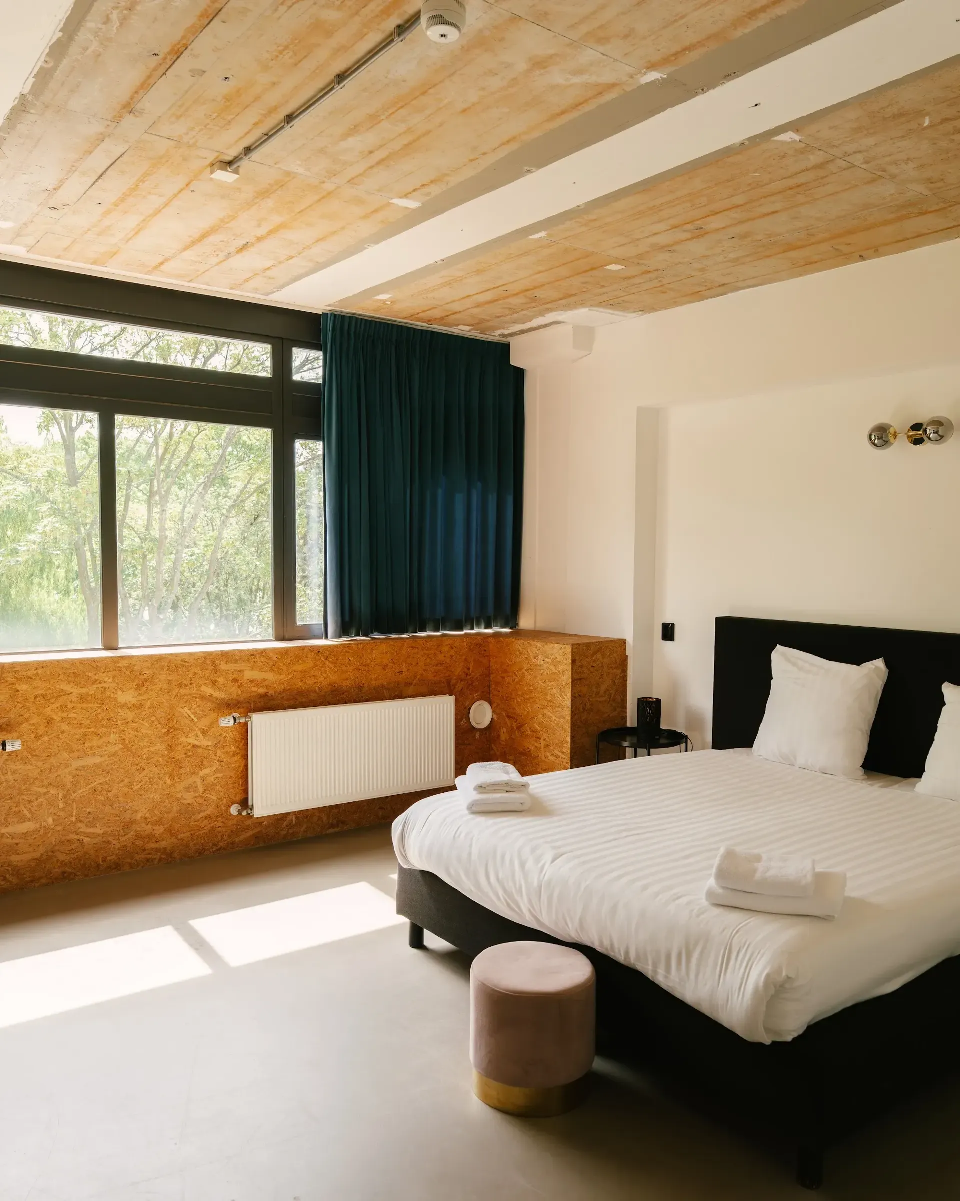 A spacious room with a large window and timber ceiling