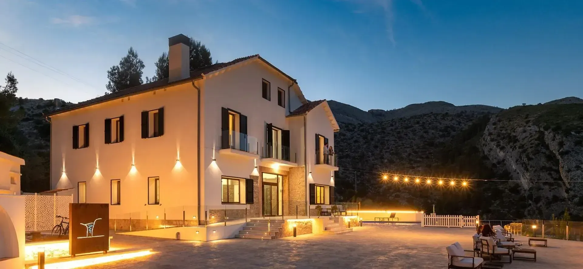 The Denia house glowing softly against the mountains at dusk